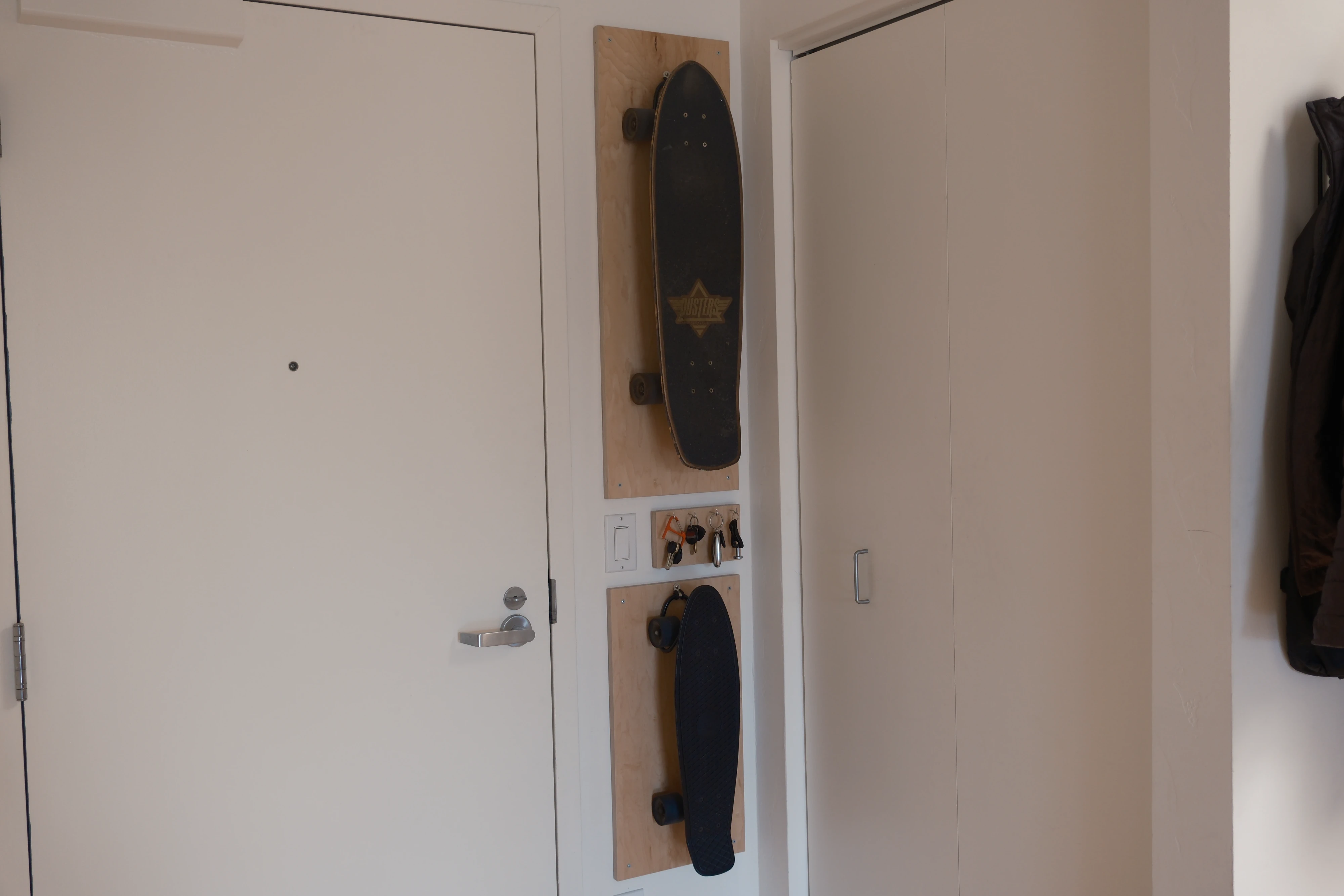 The skateboard and key mounts on a wall by a door